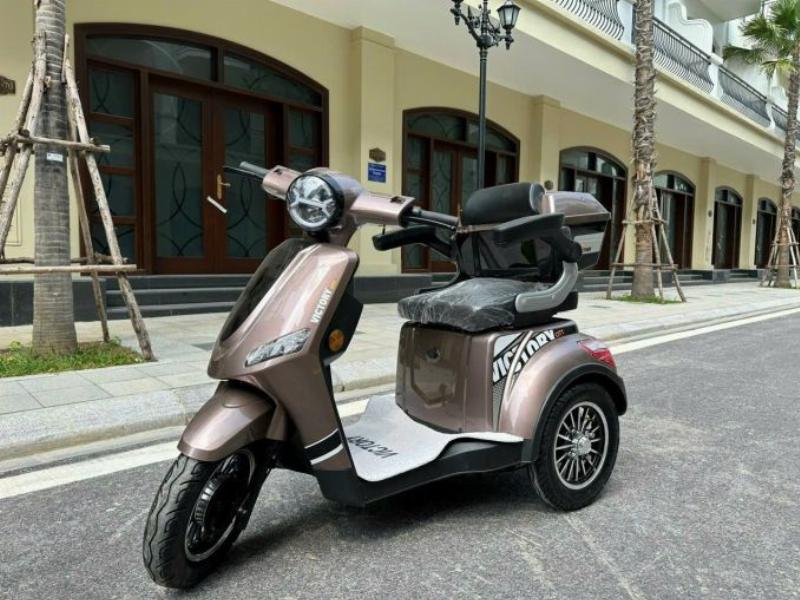 Người cao tuổi hoặc người khuyết tật đang lái thử xe đạp điện ba bánh, thể hiện sự dễ dàng và an toàn khi điều khiển.