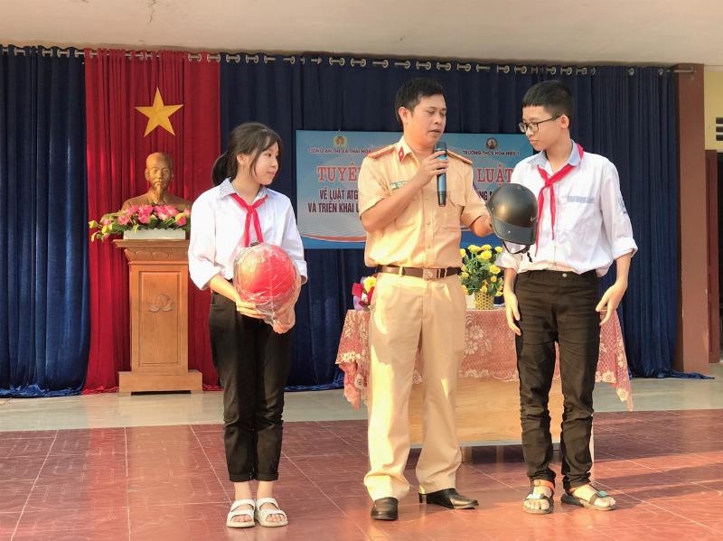 Một học sinh 12 tuổi đang đội mũ bảo hiểm và điều khiển một chiếc xe đạp điện nhỏ gọn trên đường, minh họa việc tuân thủ quy định an toàn và luật giao thông Việt Nam.